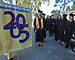 Grads file into Greek Theatre behind class banner