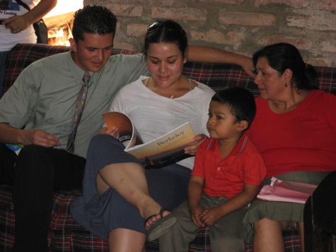  Angela's brother, Henry, her nephew, Hector, and her mother, Blanca, look at a commemorative book about Berkeley.