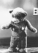 a black and white photo of an upright teddy bear