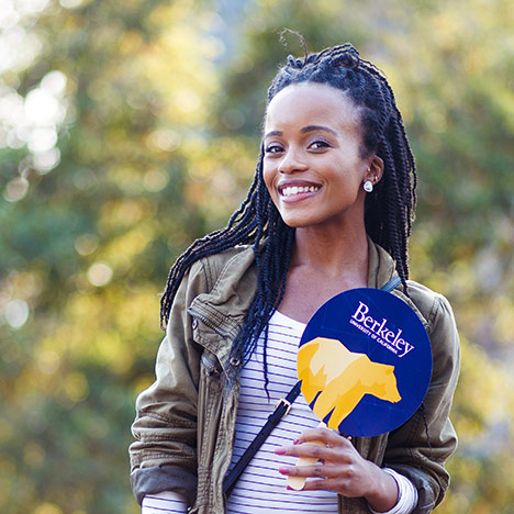 Black student holding a Berkeley bear paddle