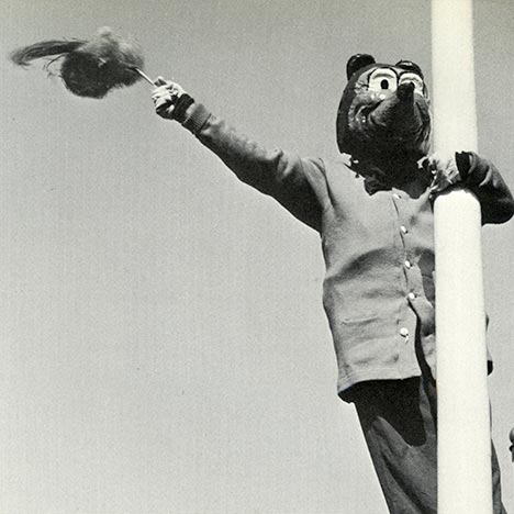 Historic black and white photo of Oski holding onto a pole