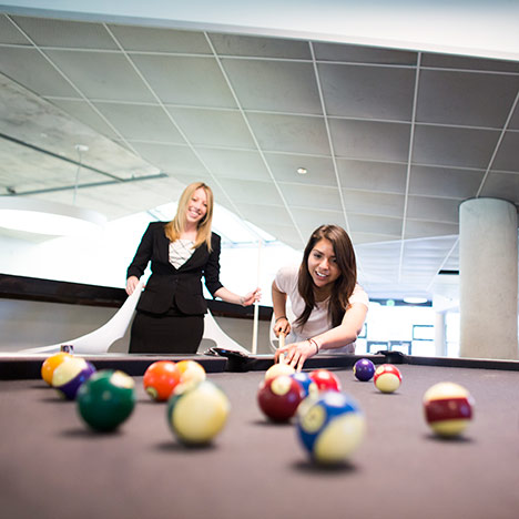 Two girls playing pool