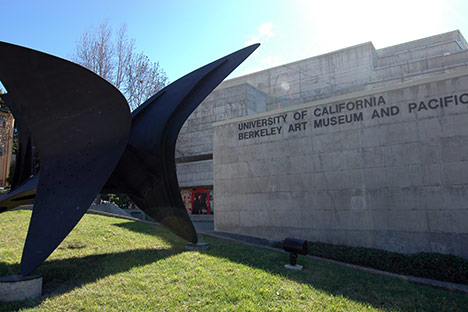 Cement building facade with large steel sculpture in front