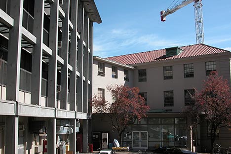 Two buildings with crane above tile roof