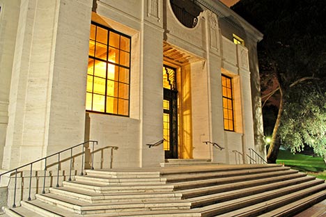 Building facade of stone with stairs and windows and door illumniated with light