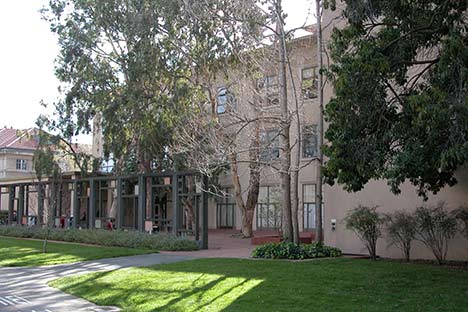 Light beige building with trees and lawn