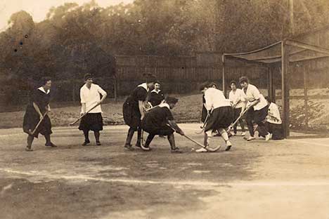 Historic photo of young women playing field hockey