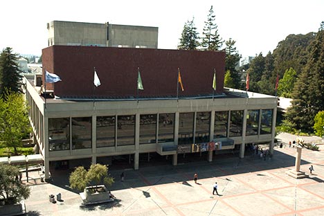 Aerial view of building with flags and large plaza below