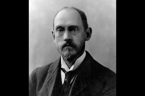 Black and white portrait of a man with beard and mustache wearing suit with vest and high collar.