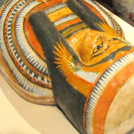 Egyptian mummy sarcophagus with orange, white, and black colors.