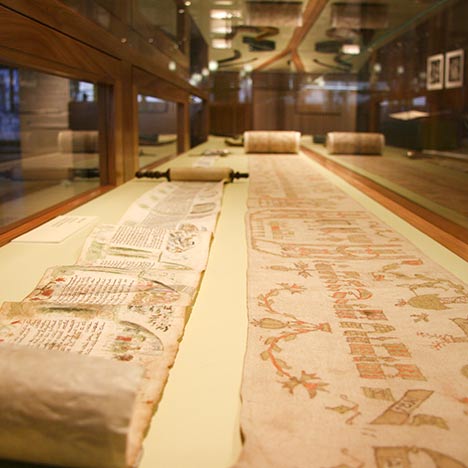 Ancient scrolls opened and displayed in glass cabinet