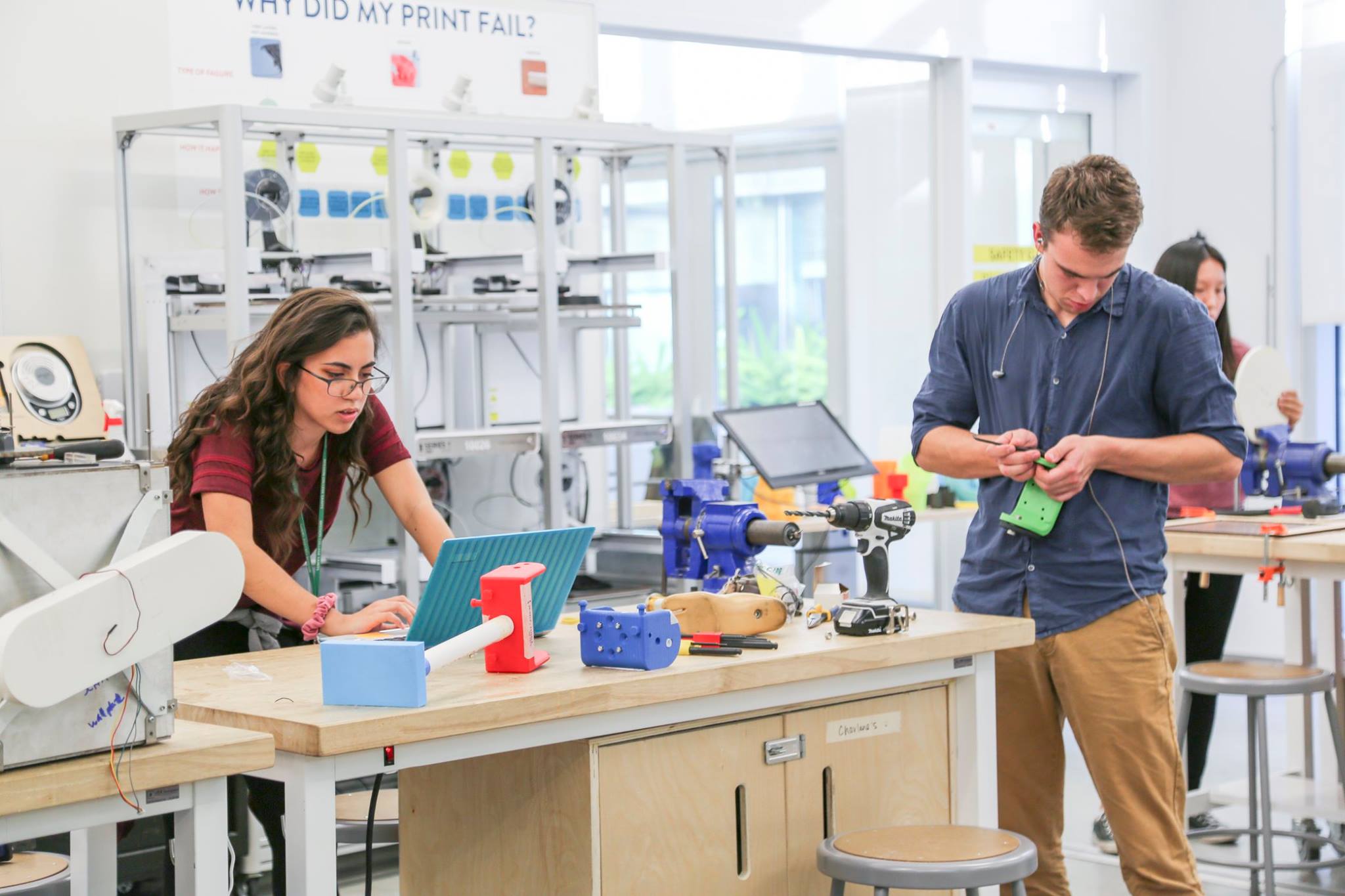 young woman and young man work at a workstation in the Jacobs Institute maker's lab