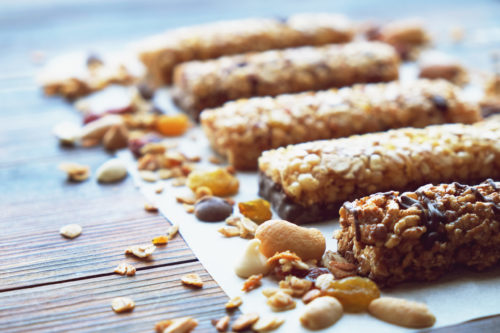 five granola/protein bars lined up in a row on a piece of paper towel