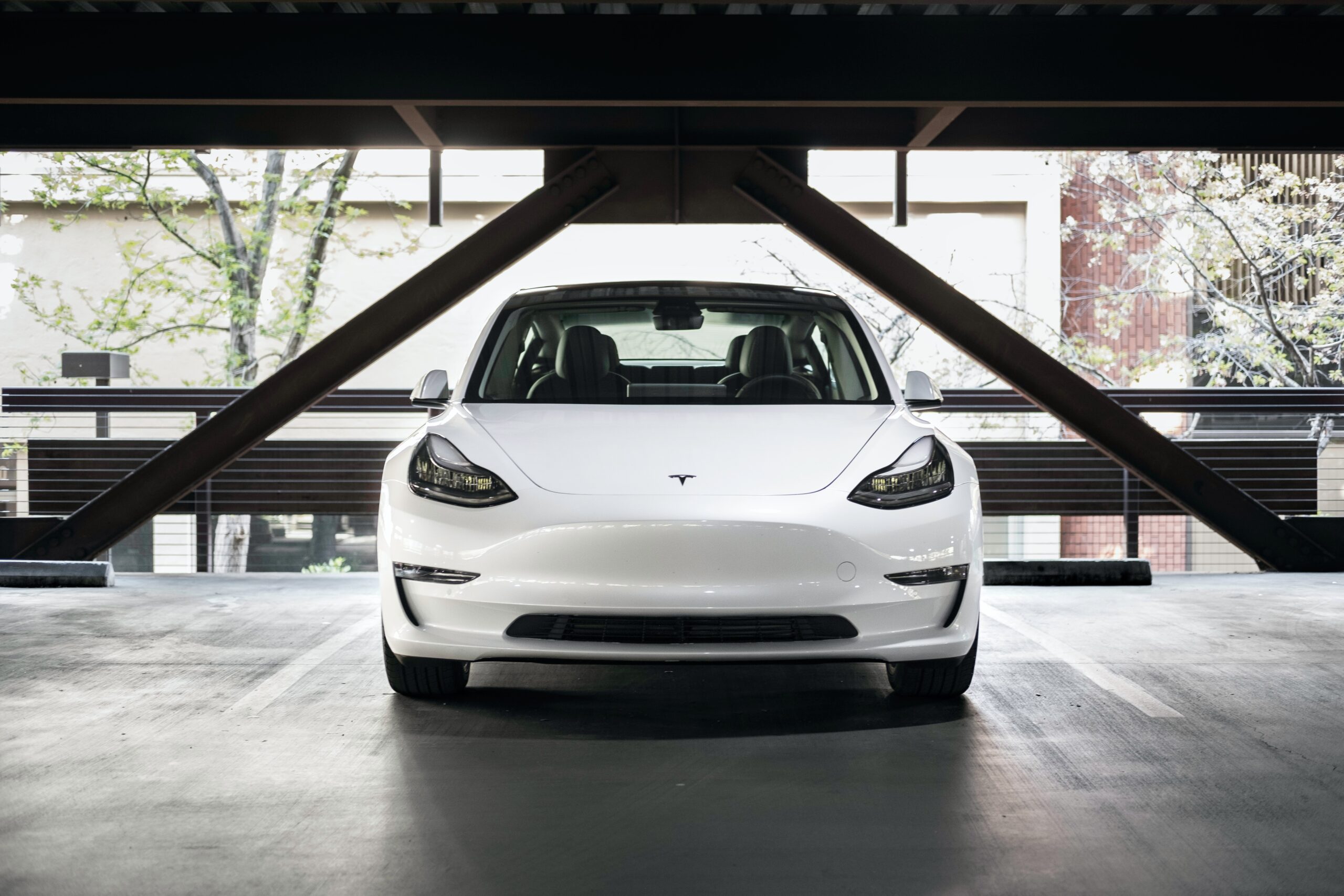 white tesla model 3 parked in a garage