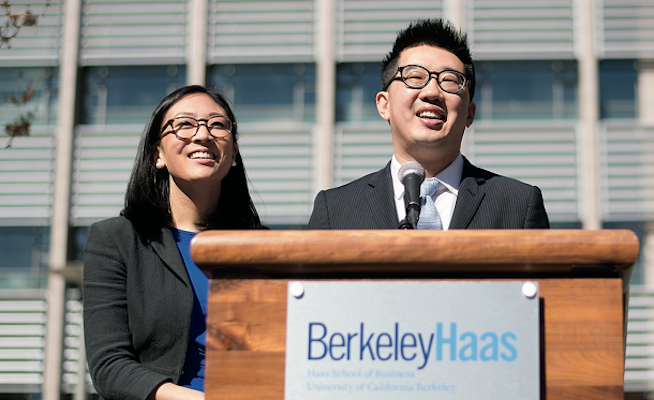 Kevin Chou stands at a podium with a woman at his side