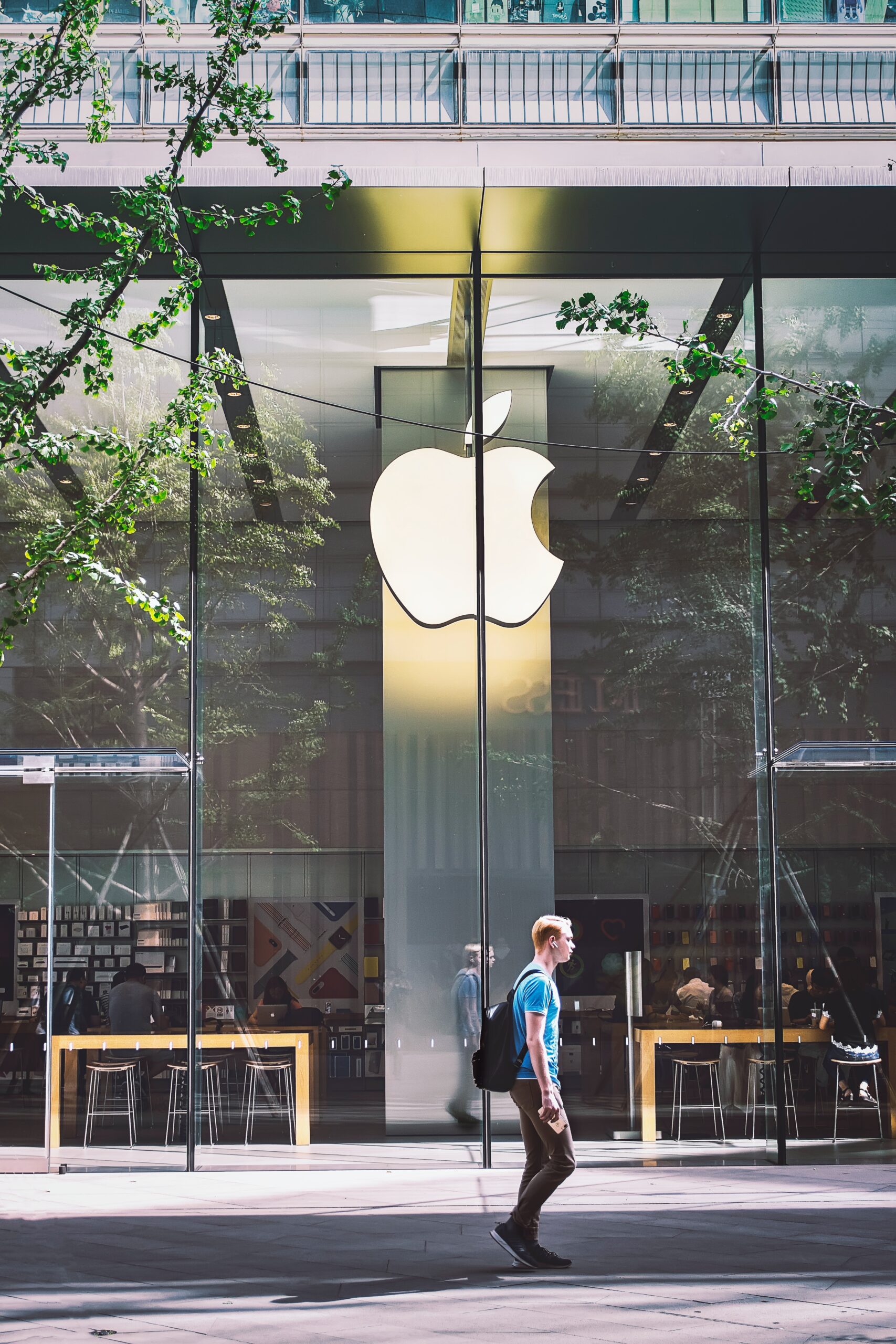 man walks by Apple store